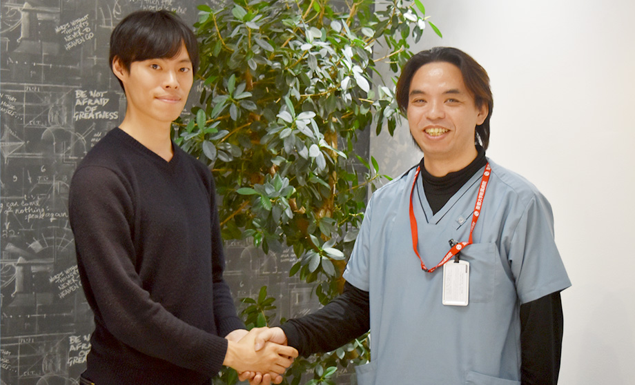 写真: 握手を交わす菊池先生と峯さん